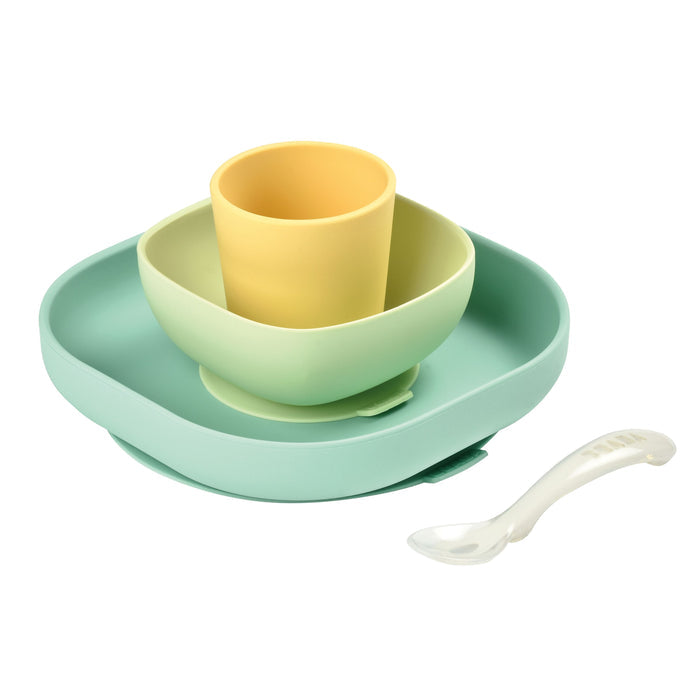 The BEABA Silicone Baby Feeding Set, BPA-free and pastel-colored, includes a green plate and bowl with a yellow cup inside plus a white spoon. Perfect for toddler feeding, it is showcased on a clean white background.