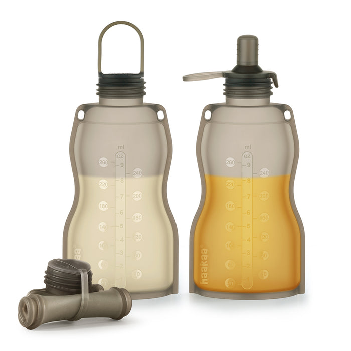 Haakaas Silicone Milk Storage Bag & Sippy Spout Combo Pack includes two translucent, reusable bottles with measurement markings. One has a screw-on handle cap and the other, filled with orange liquid, features a sippy spout. Two charcoal filter cartridges enhance its practicality for eco-conscious parents.