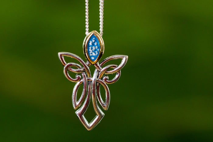 Sterling silver guardian angel pendant with a gold head and blue marbled gemstone, hanging from a silver chain