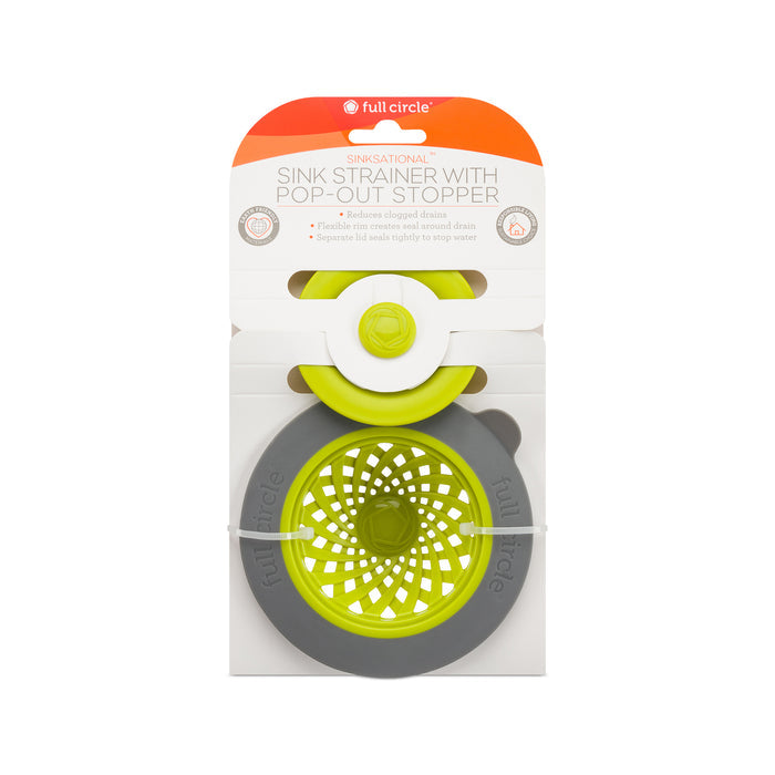 The Full Circle Sinksational Sink Strainer, eco-friendly with a pop-out stopper, features gray packaging and a lively green center to help prevent clogged drains and collect food waste efficiently.