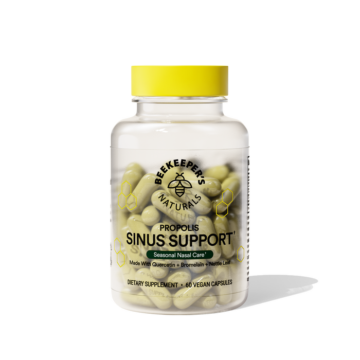 A clear bottle with a yellow cap contains beige capsules labeled Sinus Support by Beekeepers Naturals. It includes text: Seasonal Nasal Care, Made with Quercetin + Bromelain + Nettle Leaf, and offers nasal and immune support. Its a dietary supplement with 60 vegan capsules.