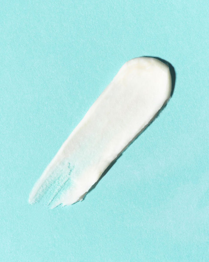 A smooth smear of SIREN SILK Bio-Retinol Hydration Cream from Earth Harbor, in white, showcases its texture with visible brush strokes on a light teal background.