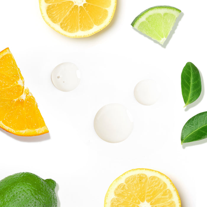 Slices of lemon, orange, and lime with fresh leaves and water droplets on a white background capture the vibrant essence of Tree To Tubs Skin Brightening Triple Action Vitamin C Serum for Face.