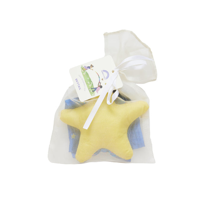 The Skytail by Sarahs Silks includes a yellow star-shaped soft toy and a folded blue, star-adorned cloth, all within a translucent white pouch with a white ribbon and cartoon-illustrated gift tag. Perfect for enhancing gross motor skills.