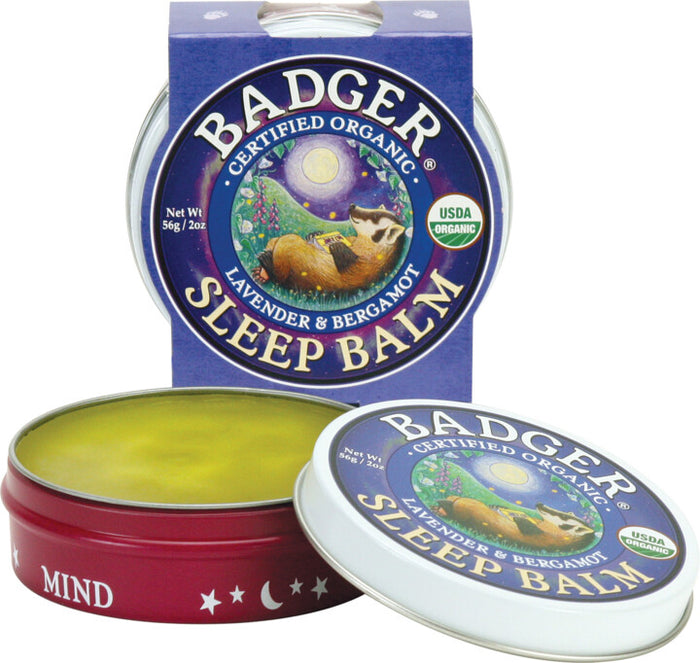 Badger Balms Sleep Balm, featuring essential oils of lavender and bergamot, offers a natural sleep remedy. The packaging showcases a night scene with a badger, and it is certified organic by the USDA.