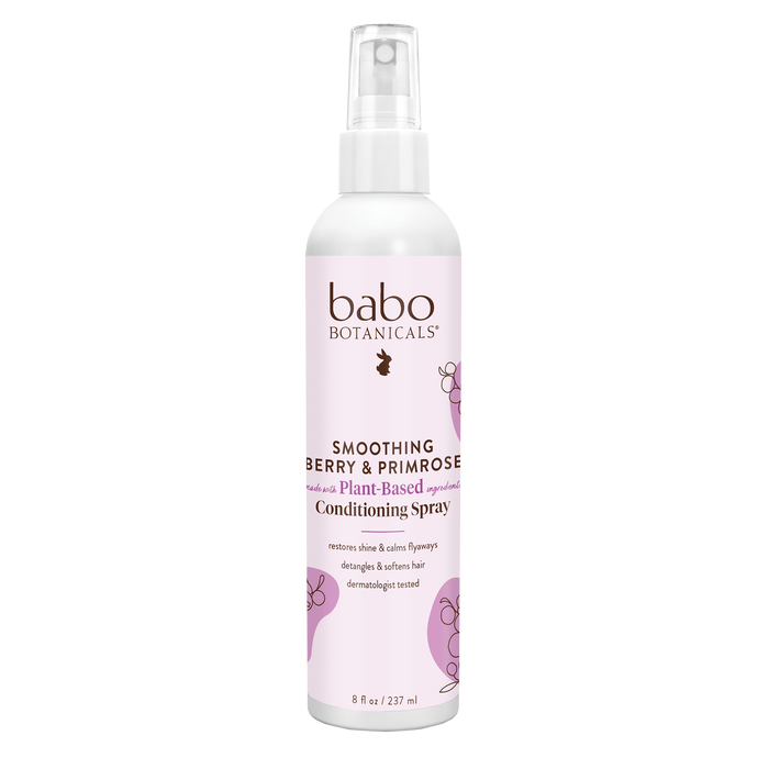 The Babo Botanicals Smoothing Conditioning Spray features a pink label with floral graphics. This silicone-free, plant-based spray tames frizz and nourishes hair for smoothness and shine.