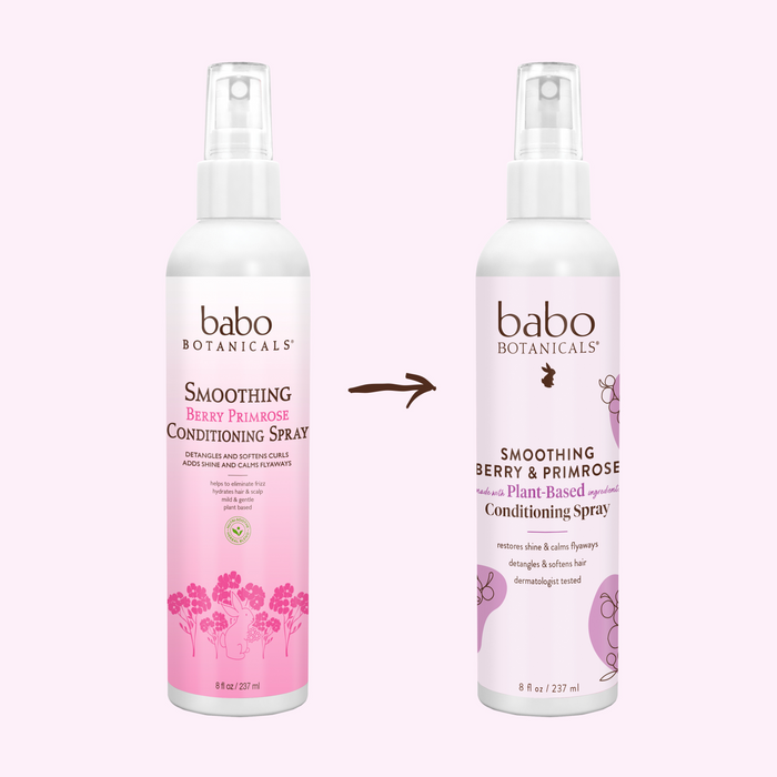 Against a light pink backdrop are two bottles of Babo Botanicals Smoothing Conditioning Spray. The bottle on the right, featuring bolder text and a sleeker design, emphasizes its frizz-taming power. An arrow between them showcases the evolution of this silicone-free conditioning spray.