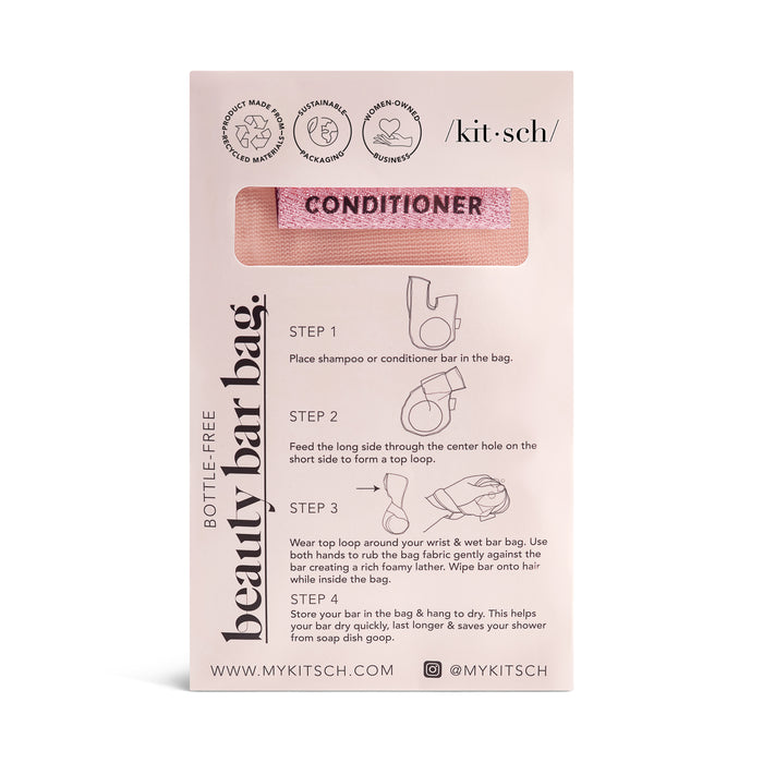 The image shows a Soap Bar Bag by Kitsch, with a pink mesh design labeled Conditioner. Perfect for upgrading your shower experience, it comes with instructions and eco-friendly icons. Its breathable design promotes optimal airflow.