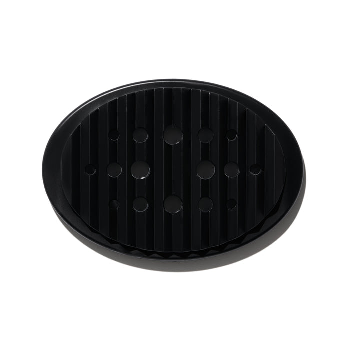 NOT!CE Hair Cos Bar Dish, a sleek black silicone accessory with vertical ridges and circular drainage holes, keeps soap dry while enhancing your sink area. This plastic-free essential stands out on a plain white background and elevates your hair care routine.