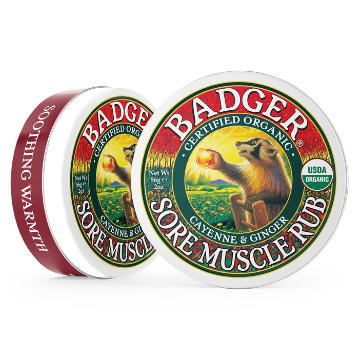 A tin of Badger Balms Sore Muscle Rub with organic cayenne and ginger. The label shows a badger holding a sun, highlighting Certified Organic and USDA Organic. This warming balm provides soothing warmth for sore muscles.