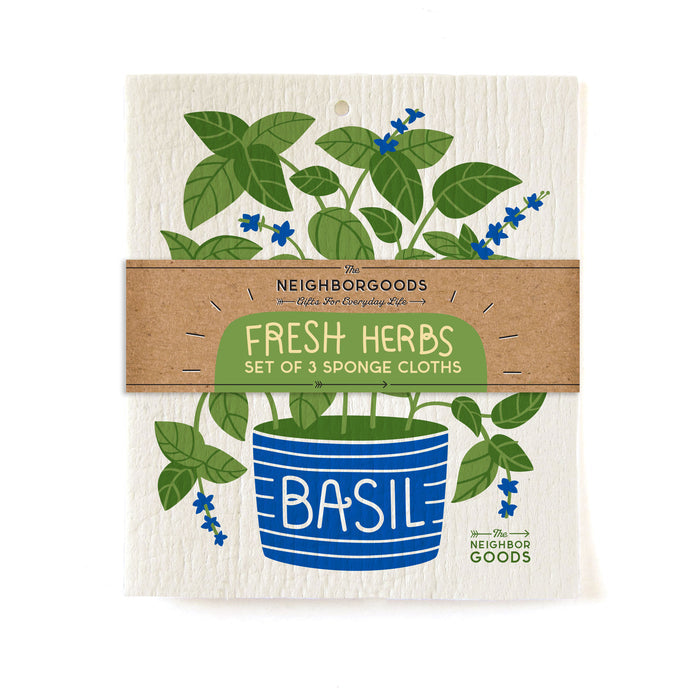 An illustration depicts a potted basil plant with green leaves and tiny blue flowers. The pot features Basil in writing and includes a brown paper band labeled Fresh Herbs Set of 3 Eco-friendly Sponge Cloths by The Neighborgoods.