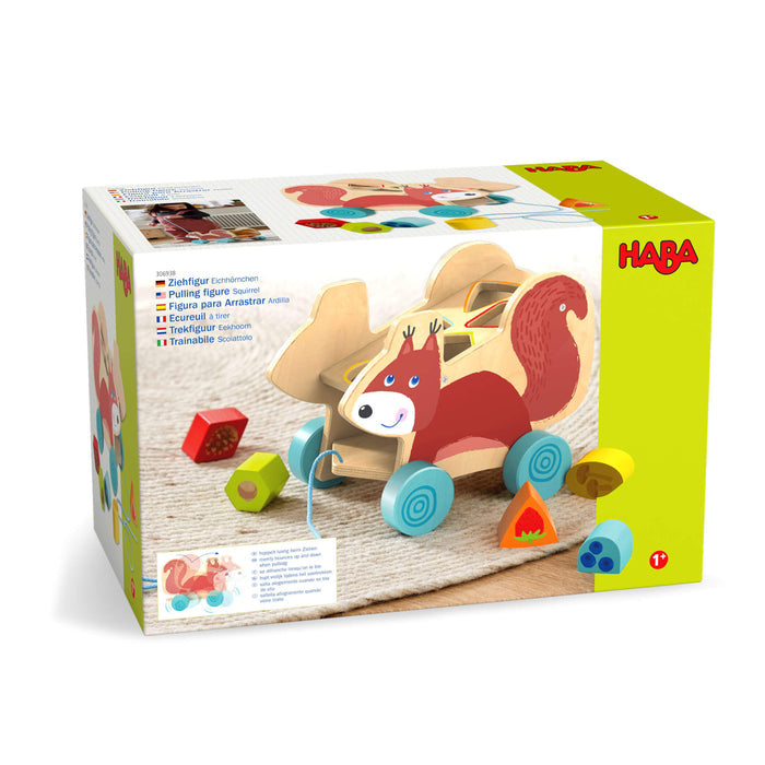 The Squirrel Pull Along Toy Sorting Box by HABA features a vibrant design on a light background, showcasing its sustainably sourced materials. This wooden toy includes shaped blocks and wheeled movement to enhance developmental skills.