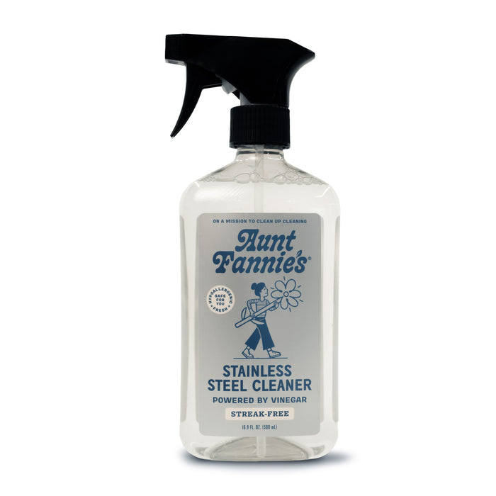 Aunt Fannies Stainless Steel Cleaner spray bottle has a vintage-style label of a person cleaning and a sleek black nozzle. It promises Vinegar Powered performance for non-abrasive, streak-free, gleaming surfaces.