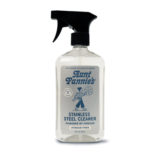 Aunt Fannies Stainless Steel Cleaner spray bottle has a vintage-style label of a person cleaning and a sleek black nozzle. It promises Vinegar Powered performance for non-abrasive, streak-free, gleaming surfaces.