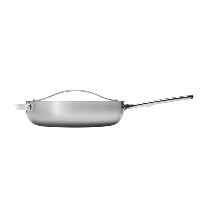 Side view of the Caraway Stainless Steel Sauté Pan, 4.5 qt, showcasing its 5-ply construction with a sleek, shiny finish. It features a long right-sided handle and a matching lid with a top handle, emphasizing durability and style in its non-toxic design.