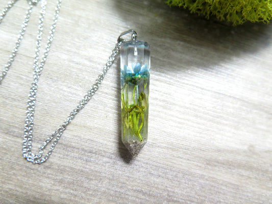 Crystal resin pendant with a blue starflower and green moss encased, cremains infused, on a silver chain