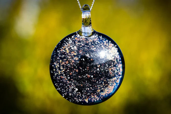 Starry Night glass pendant with cremation ashes featuring a dark background and colorful specks.