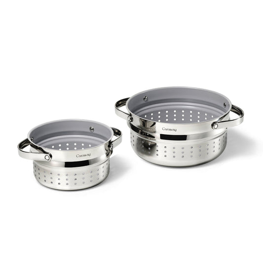 The Steamer Duo, by Caraway, features two metallic colanders with a polished finish and perforated holes, medium and large in size. They are displayed side by side on a white background with the brand name on a dark label.