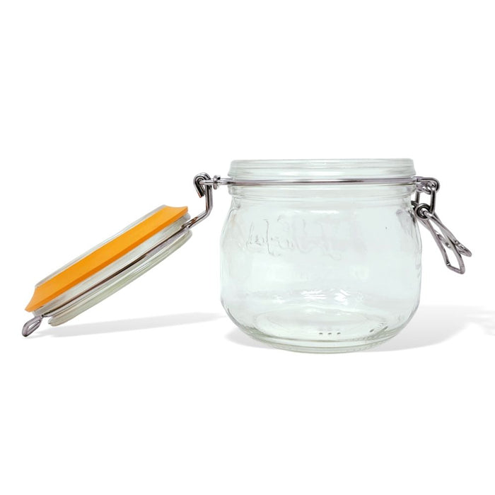 The Le Parfait Storage and Canning Glass Jar, 500ml, is open on a white background. Made from durable, recyclable glass, it features a hinged metal clasp and an orange rubber seal that ensures an airtight closure, making it ideal for food storage.