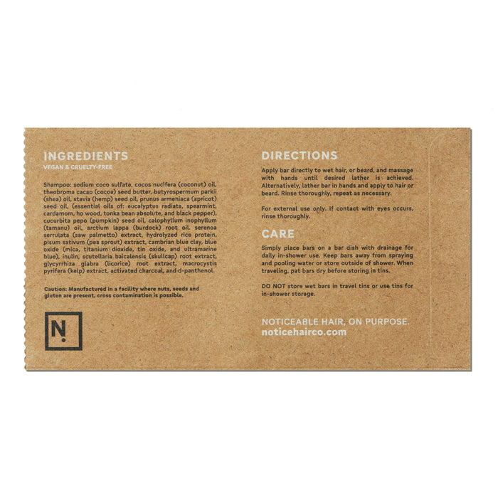 The minimal brown packaging of the Suds Shampoo Bar by NOT!CE Hair Co details its ingredients, usage, and care instructions, highlighting its commitment to vegan, cruelty-free, and plastic-free hair care without cross-contamination.