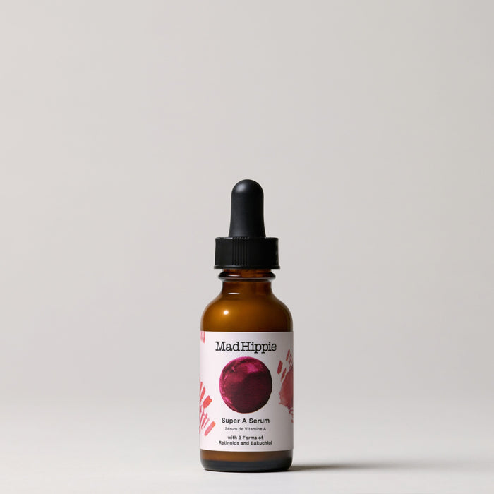 A Mad Hippie Super A Serum bottle with a black dropper cap and a stylized red circle design sits against a neutral backdrop, promoting youthful skin and wrinkle reduction.