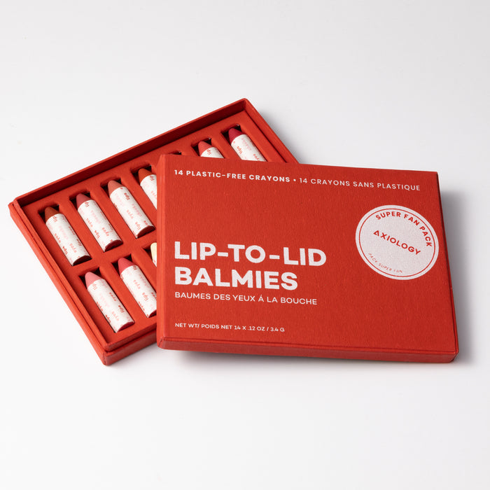 Axiologys Super Fan Pack is a red box containing 14 multi-use, plastic-free crayons. The open box displays crayons, each in white paper. The lid, to the right, showcases the product name and details in clean white text.