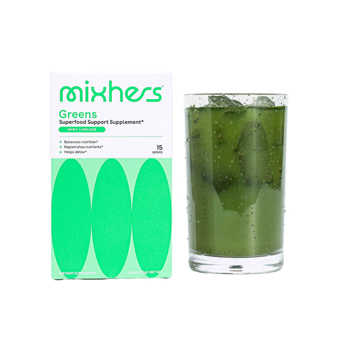 A box labeled Mixhers Superfood Greens Supplement Powder, ideal for womens nutrition and detox support, sits next to a clear glass of green liquid with ice. The white box features bright green oval designs emphasizing the benefits of this greens supplement.