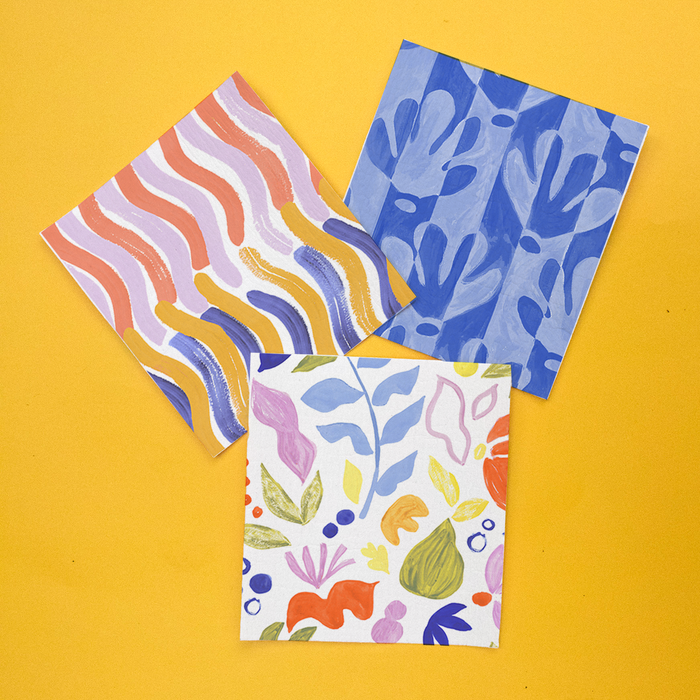 Supra Enduras Swedish Dishcloths feature three vibrant prints on a yellow background: top-left pink and gold wavy lines, top-right blue abstract shapes, and a bottom filled with multicolored floral patterns. Ideal for eco cleaning with their superb absorbency.