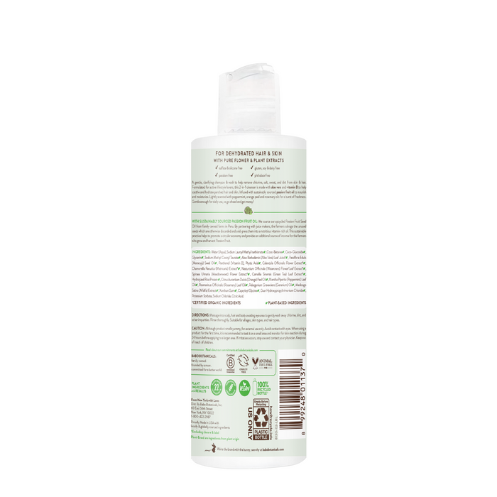 A bottle of Babo Botanicals Swim & Sport Shampoo and Wash is shown from the back, displaying a green and white label with usage instructions, ingredient list, cruelty-free and vegan certifications. It has a hypoallergenic formula and a flip cap.