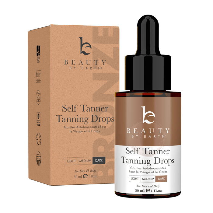 A Beauty by Earth Tanning Drops bottle, brown with a black dropper, sits in front of its box. It comes in Light, Medium, and Dark shades with organic ingredients for a natural tan on face and body, 30 ml.