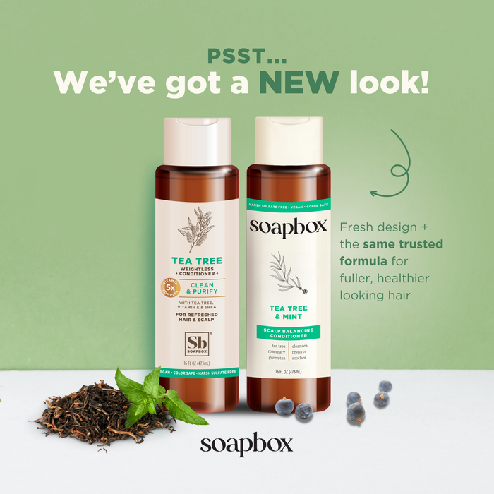 Two bottles of Soapbox Tea Tree & Mint shampoo and conditioner with 5X vitamin complex. Features a new look with the same formula for healthy hair. Offers lightweight hydration that invigorates your senses, surrounded by mint leaves and berries on a light background.