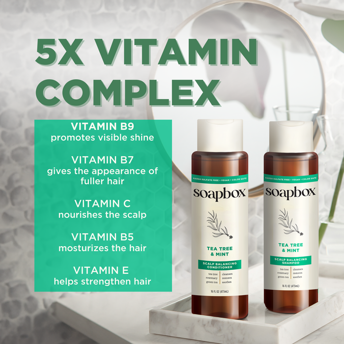 Image of Soapbox Tea Tree & Mint Scalp Balancing Shampoo bottles on a bathroom counter with text highlighting the 5X Vitamin Complex benefits: tea tree oil for scalp balance, visible shine, fuller hair, enhanced nourishment, moisture retention, and strength.