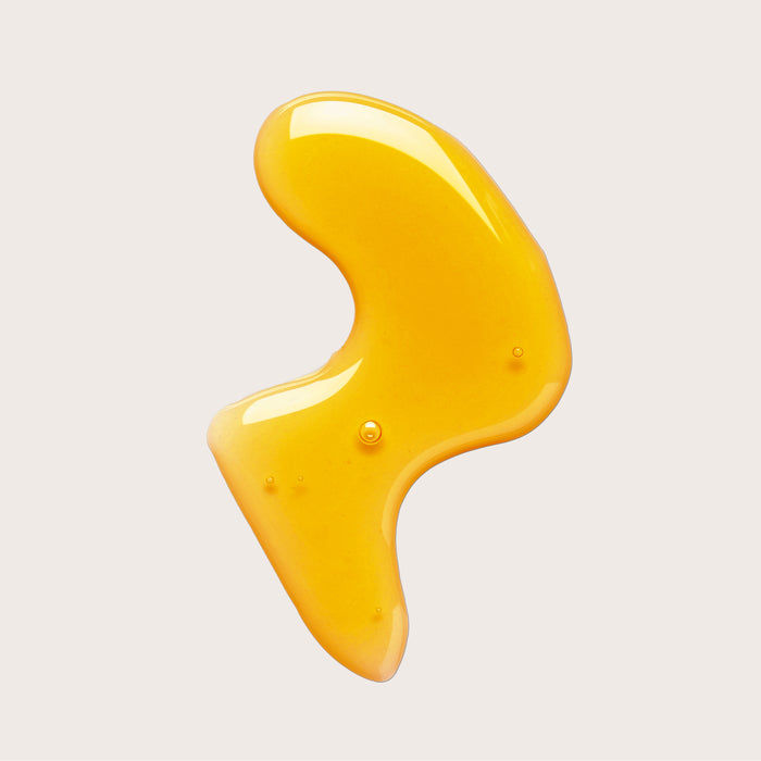 A glossy, abstract yellow-orange blob with a smooth surface and rounded edges evokes the richness of The Body Oil Spritz by Everist, set against a plain light background.