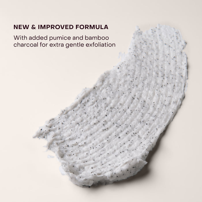 A smear of white Everist The Exfoliating Body Wash Concentrate with black specks is spread on a beige surface. Text above: NEW & IMPROVED FORMULA. Now with pumice and bamboo charcoal to gently exfoliate for better body care.