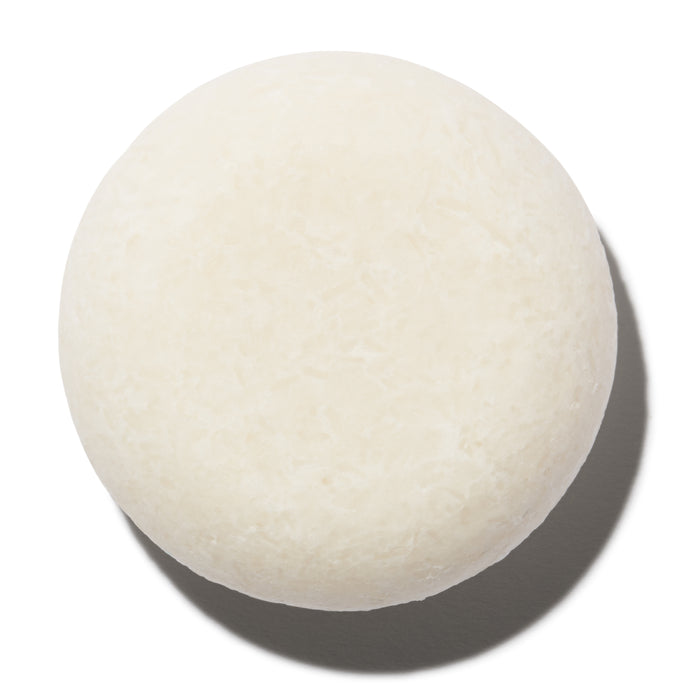 A round, white Hydrator Shampoo Bar from NOT!CE Hair Co sits on a plain white background, casting a soft shadow beneath—a perfect choice for anyone seeking plastic-free hair care and the moisturizing benefits of The Hydrator.