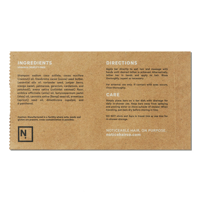 The Hydrator Shampoo Bar by NOT!CE Hair Co features brown packaging listing coconut sulfate and essential oils. Directions include wet hair massage, lather, rinse. Emphasizes its vegan, cruelty-free, and plastic-free hair care commitment.