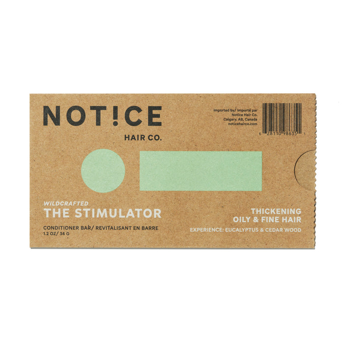 The Stimulator Conditioner Bar by NOT!CE Hair Co arrives in a brown cardboard package that promises hair growth, highlights Wildcrafted, and is suited for Thickening Oily & Fine Hair. It offers eucalyptus and cedar wood scents, features a central green rectangle, and is sustainable and plastic-free.