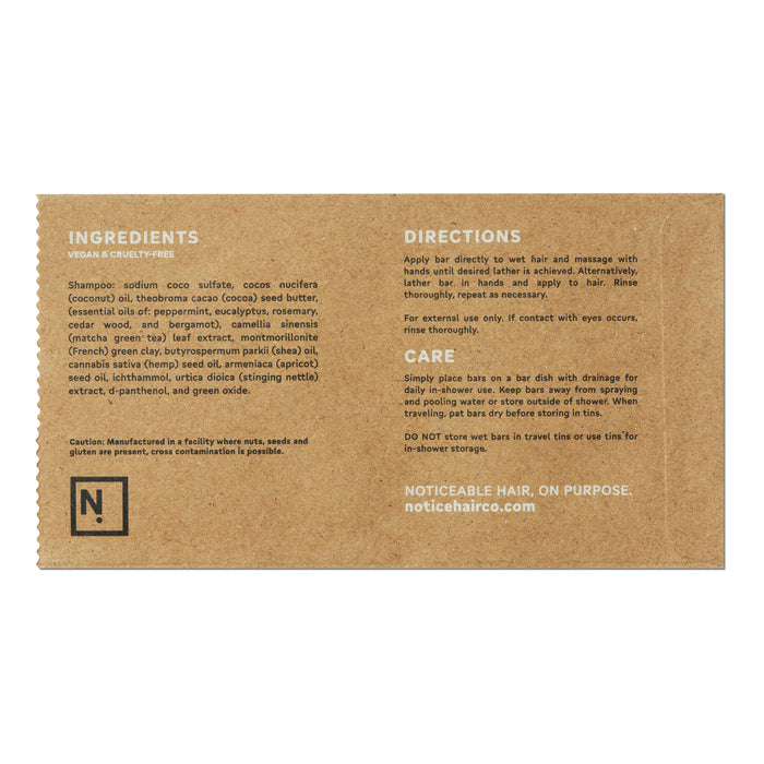 Kraft paper packaging presents The Stimulator Shampoo Bar by NOT!CE Hair Co, a vegan, cruelty-free product promoting hair growth. It includes oils and extracts while warning against allergens. Experience plastic-free hair care with contact details provided for inquiries.