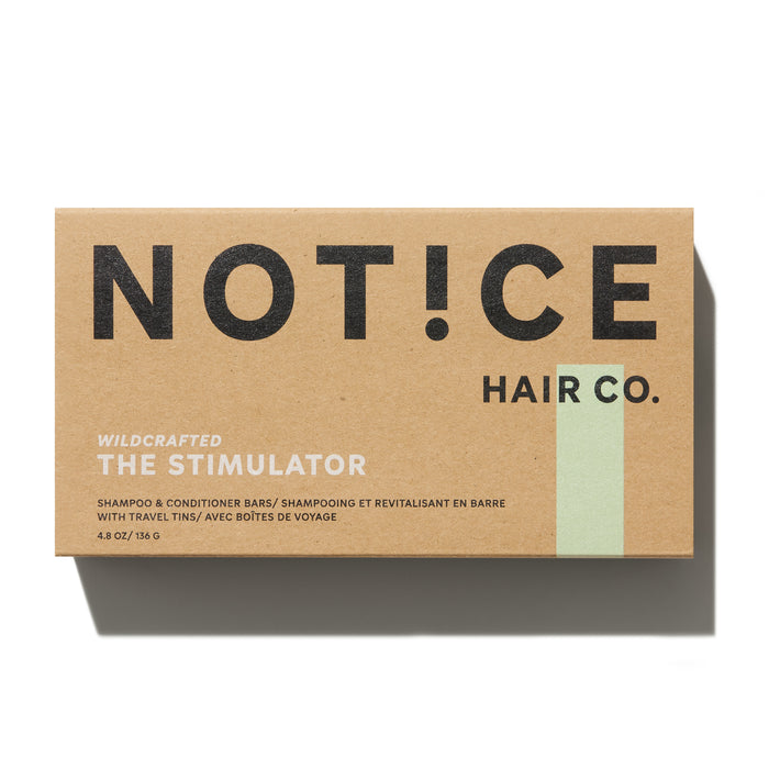 The NOT!CE Hair Co. packaging for The Stimulator Travel Set features shampoo and conditioner bars enriched with French green clay, housed in travel tins. The minimalist design on the box, which reads Wildcrafted, elegantly highlights this innovative hair care brands appeal.