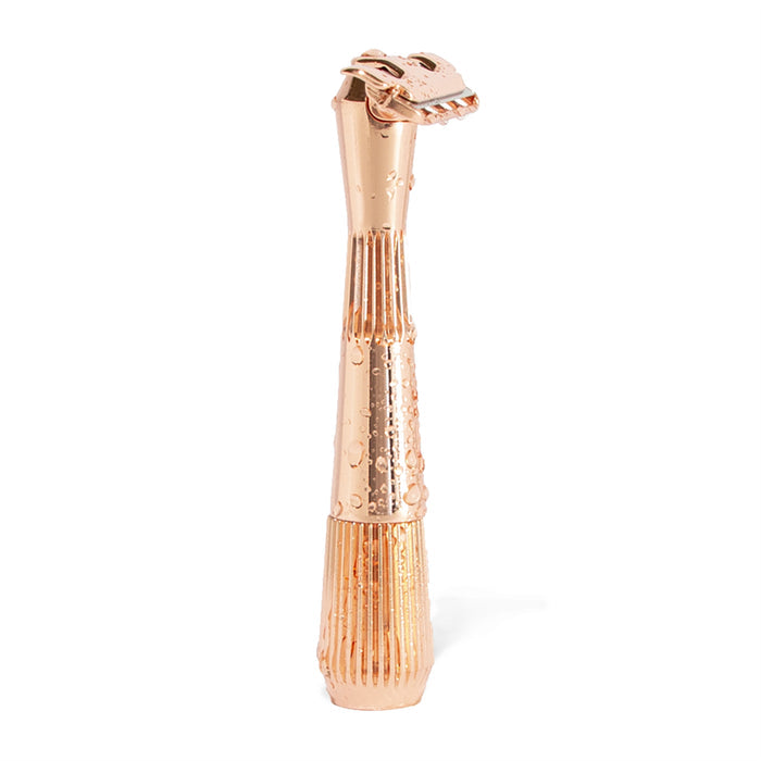 A gold Twig Plastic-Free Razor by Leaf Shave, with an intricately designed, tall, slender handle and a decorative razor-like cap. Its textured surface appears wet with droplets, elegantly standing against a flat white background.