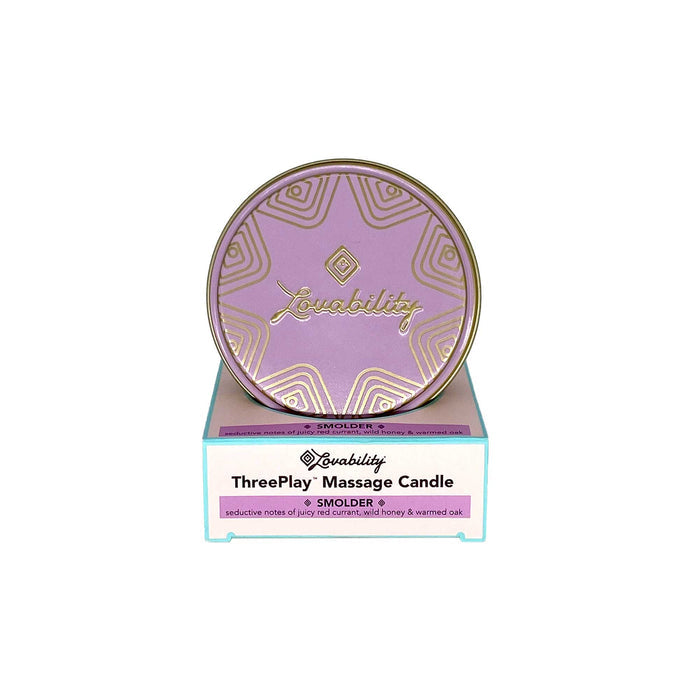 The image showcases a Lovability ThreePlay Massage Candle in the Smolder scent, serving as both sensual massage oil and ultra-hydrating moisturizer. It features a pink lid with a gold geometric design on white packaging accented by teal edges, emphasizing product details.