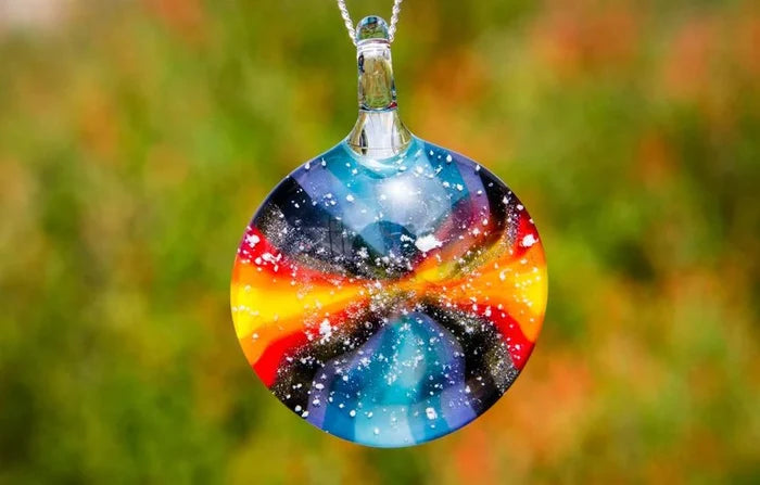 Round tie dye glass pendant on a silver chain infused with cremation ashes