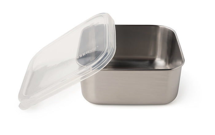 A stainless steel U-Konserve To-Go Medium Container with a partially open clear plastic lid sits empty on a white surface, perfect for plastic-free food storage.