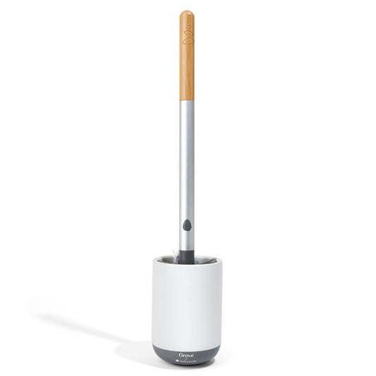 The Grove Co. Toilet Brush with Replaceable Head boasts a gray, wood-textured handle and stands upright in a white holder on a pristine white background.