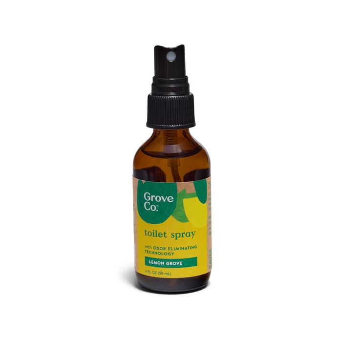 A 2 fl oz (59 mL) brown glass bottle of Grove Co. Toilet Spray with a black nozzle highlights its odor-elimination technology and lemon grove scent, elegantly set against a white background.