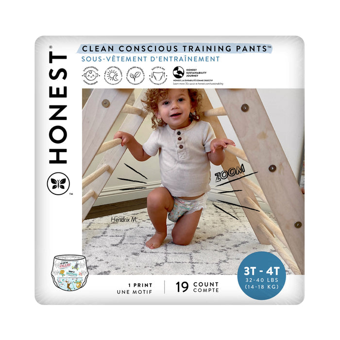 A toddler playfully stands in a wooden structure, wearing The Honest Companys Training Pants - 3T/4T. These training pants are ideal for potty-training with an absorbent core and come in a 19-count pack for children weighing 32-40 lbs. Clean Conscious Training Pants is prominently displayed on the packaging.
