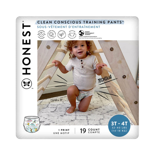 A toddler playfully stands in a wooden structure, wearing The Honest Companys Training Pants - 3T/4T. These training pants are ideal for potty-training with an absorbent core and come in a 19-count pack for children weighing 32-40 lbs. Clean Conscious Training Pants is prominently displayed on the packaging.