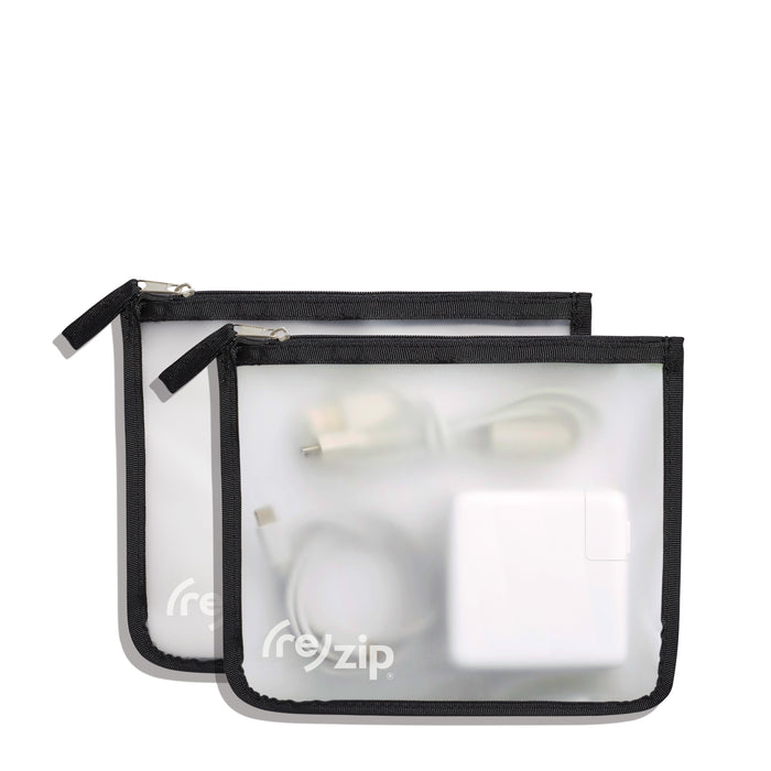 Two translucent, reusable Travel Organizer Zipper Bags - Medium by (re)zip, with black borders, hold electronic accessories like a power adapter and cables. These travel bags are displayed on a white background.