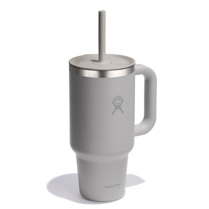 A 32 oz grey Hydro Flask travel tumbler with a handle and straw, featuring a stainless steel rim and visible logo on the front. It includes a leak-resistant lid to keep your drinks secure on the go.