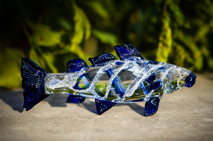 Clear glass trout figurine with dark blue fins infused with cremains.
